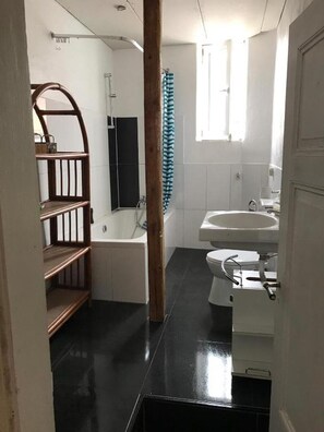 Ein Badezimmer mit Badewanne, Toilette und Waschbecken.