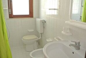 Une petite salle de bain comprenant des toilettes, un bidet et un lavabo.