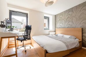 A bedroom with a bed, desk, chair, and large windows. - Modern and spacious 5-bedroom family home (Pringy)
