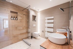 A modern bathroom with a glass-enclosed shower, a toilet, a sink with a mirror, and a towel rack. - Modern and spacious 5-bedroom family home (Pringy)
