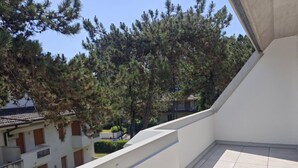 Ein Balkon mit Blick auf Bäume und Gebäude.