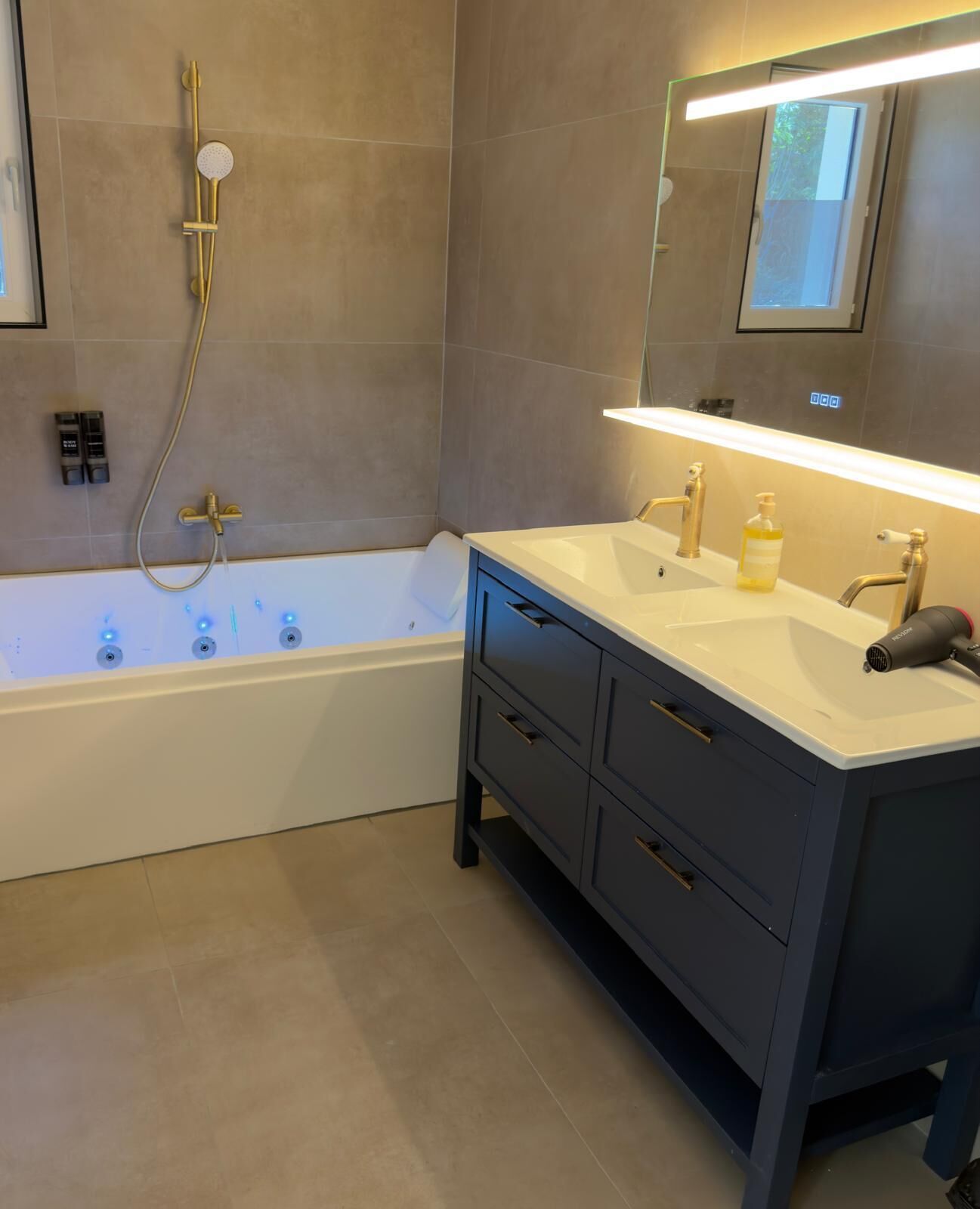 Un baño moderno con bañera, tocador y espejo.