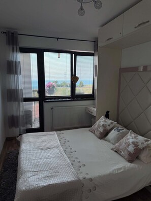 A bedroom with a bed, a radiator, a window with blinds, a curtain, and a ceiling light fixture. - Villa Bellerose direct seaview, 4 bedrooms, private heated pool - golf - beaches (Bozhurets)