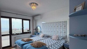 Une chambre moderne avec un grand lit, des étagères intégrées et une vue par la fenêtre.