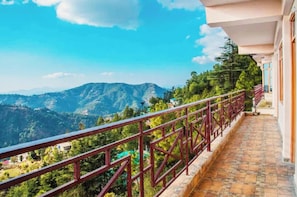A balcony with a red railing overlooking a mountainous landscape. - Hotel Mount Breeze Nainital (Nainital)