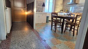 A kitchen with a dining area, a window, and a door leading to another room. - Fourasine family home 300m from the beach (Fouras)