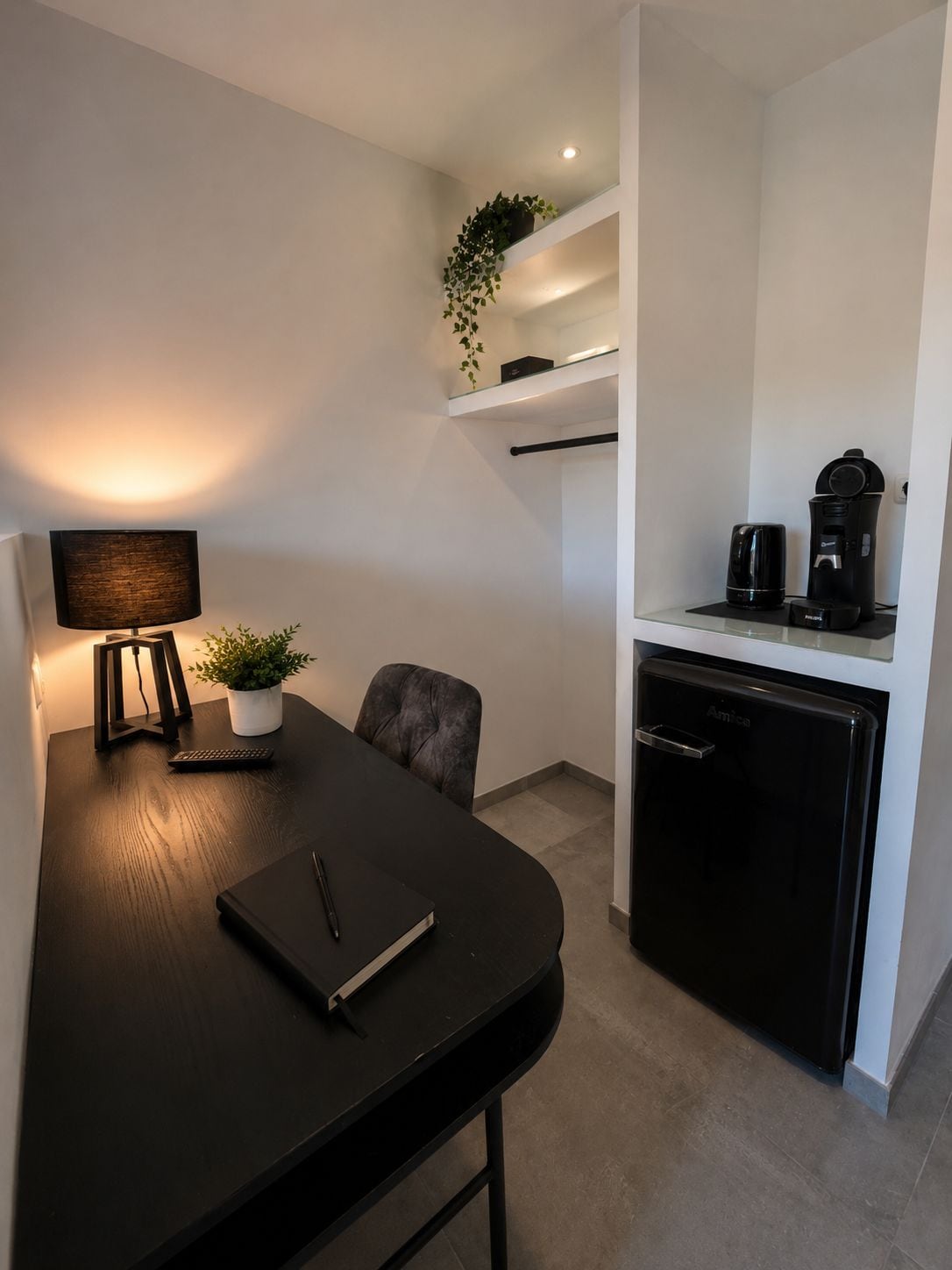 A modern kitchen with a black countertop, a coffee maker, and a dishwasher.