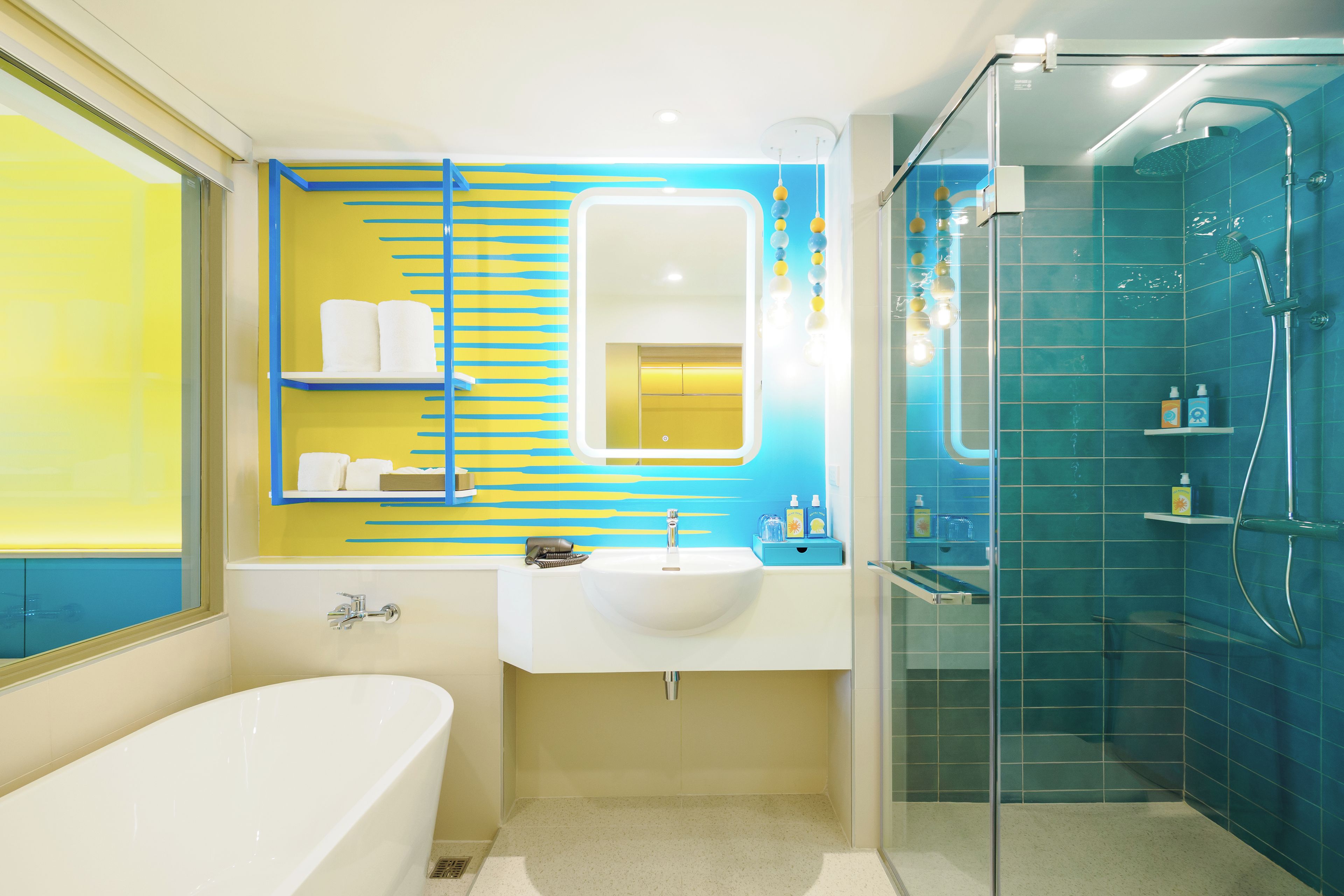Une salle de bain moderne équipée d’une baignoire, d’un lavabo et d’une douche séparée par des parois en verre.