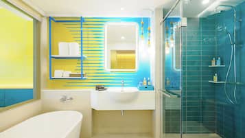 Un baño moderno con bañera, lavamanos y zona de ducha con mampara de vidrio.