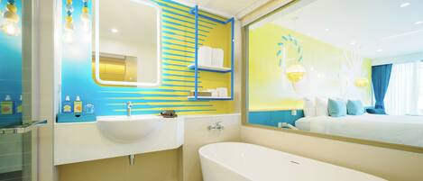 Un baño moderno con una bañera grande, un lavabo doble y un espejo con marco azul.