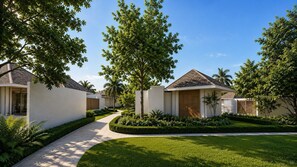 A residential area with modern houses, a paved walkway, and well-maintained greenery.