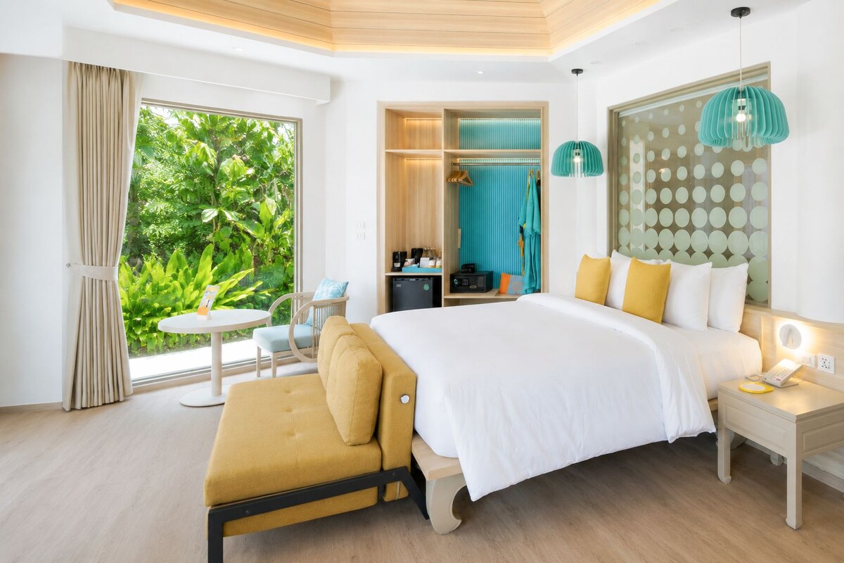 Un dormitorio con cama, mesita de noche y vistas al exterior.