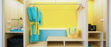 A walk-in closet with a bench, shelves, and a hanging robe rack.