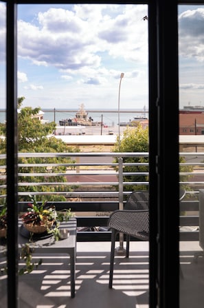 A balcony with a view of a bridge, a street, and a body of water. - Alexandra Boutique Residence Downtown  (Alexandroupoli)