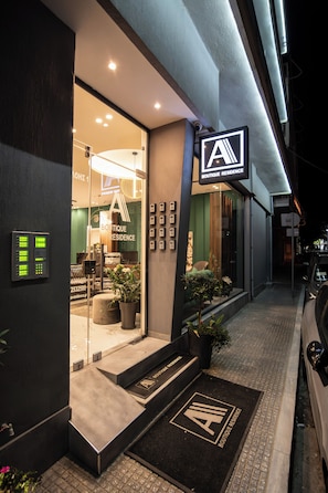A boutique residence with a glass entrance, a reception desk, and a car parked outside. - Alexandra Boutique Residence Downtown  (Alexandroupoli)