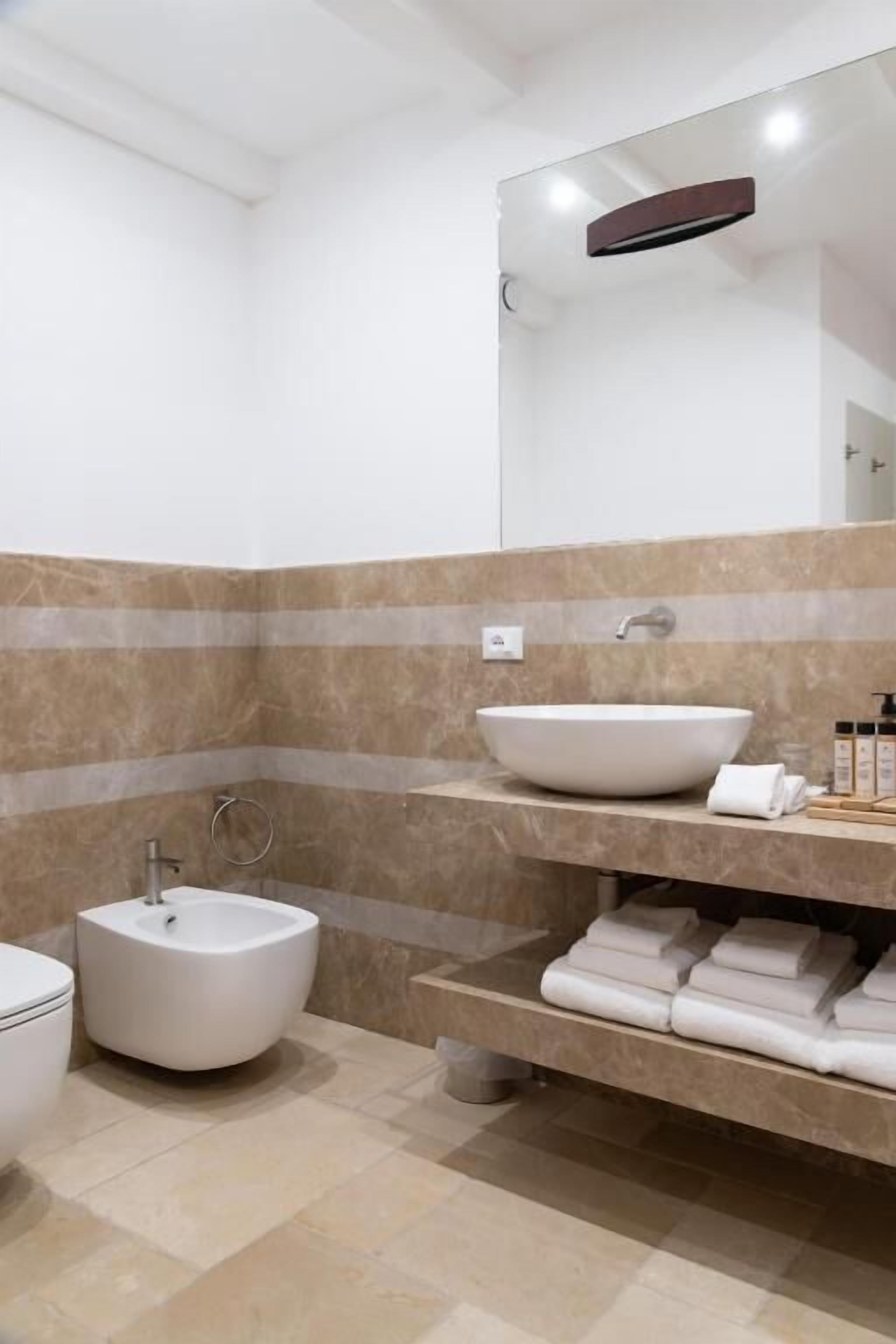 Een moderne badkamer met een groot wastafel, een toiletbril en een spiegel.