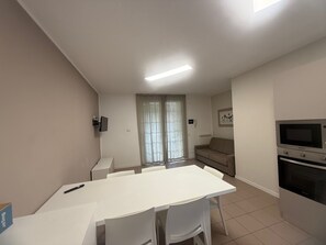 Eine moderne Küche mit Mikrowelle, Backofen und einem Essbereich mit Tisch und Stühlen.