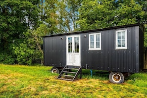 A black mobile home with a front door, two windows, and a ramp leading to the entrance. - Golden Grape in Oakengrove Vineyard (Buckinghamshire)