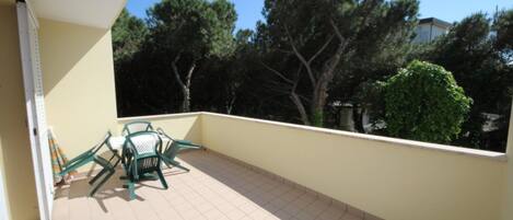 A balcony with tiled flooring, a chair, and a table.