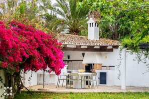A white building with a tiled roof, a chimney, and a patio with outdoor furniture. - Villa SAO PAULO by Abahana Villas (Moraira)