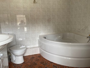 A bathroom with a toilet, sink, and a freestanding bathtub. - Le Relais Des Hirondelles – Camélia Room with Private Garden (Chaumont-en-Vexin)