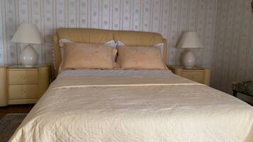 A bedroom with a bed, two bedside tables, and a nightstand.