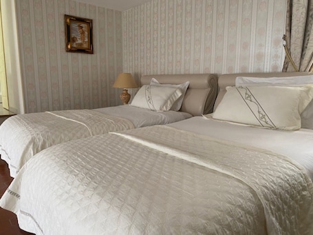A double bed with a quilted cover, a bedside lamp, and a framed picture on the wall.. Le Relais Des Hirondelles - Hortensia Room with Garden