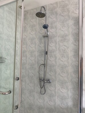 Een douche met een handdouche, een wandmengkraan en een doucheslang.
