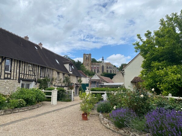 A quaint village street with historic buildings, a church, and a gravel path. - Le Relais Des Hirondelles Guest Room – Magnolia, Garden on the Property (Chaumont-en-Vexin)