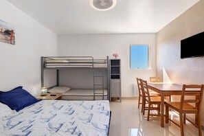 A compact room with a bunk bed, a desk, and a chair.