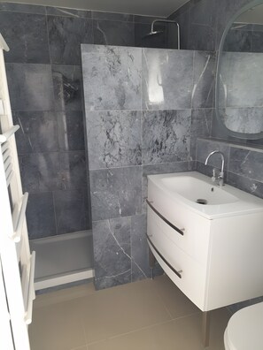 A modern bathroom with a shower, a sink, and a mirror. - Ceraria Apartment with Shared Pool (Loupian)