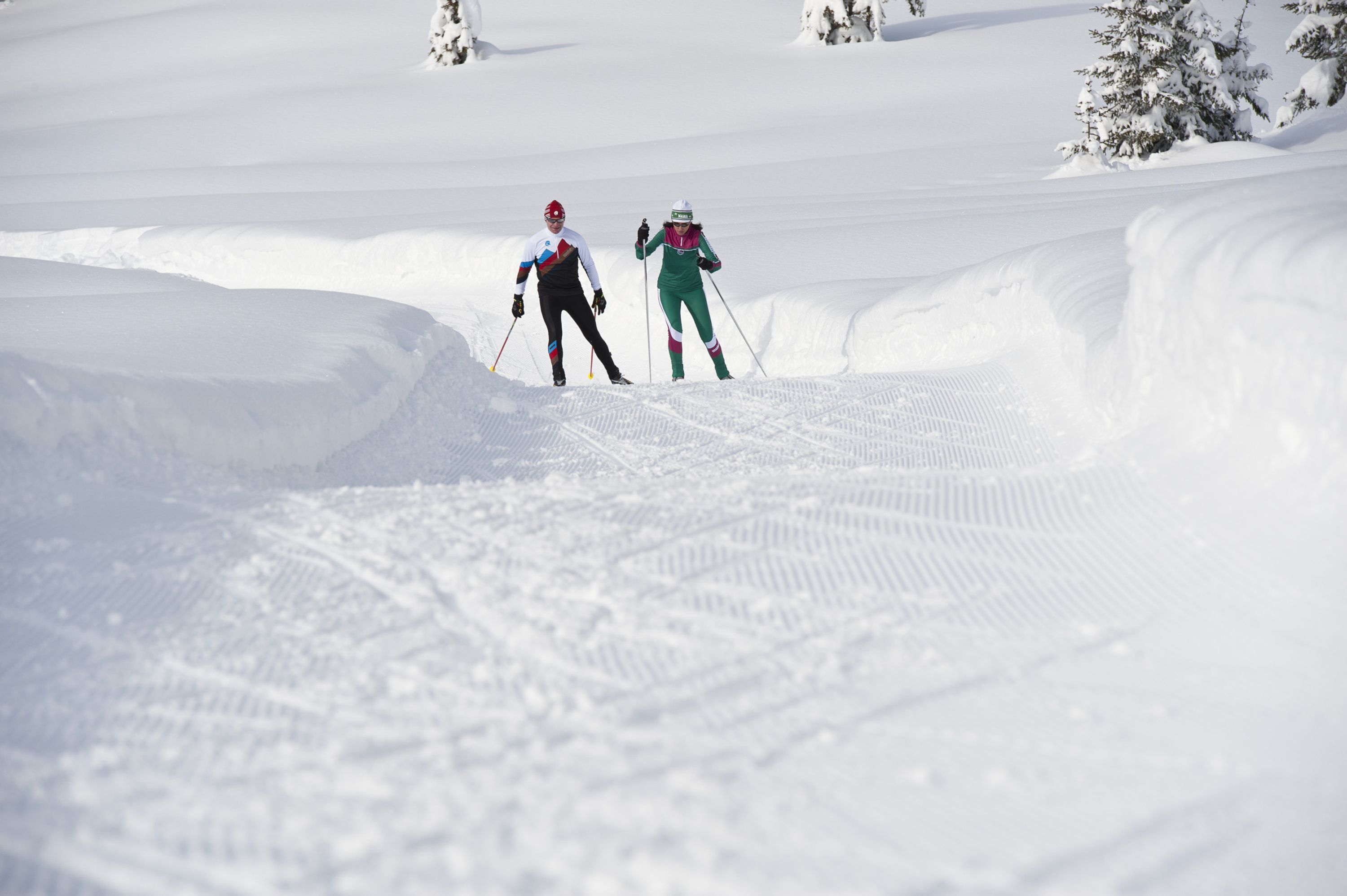 Zwei Skifahrer auf einem verschneiten Hang.