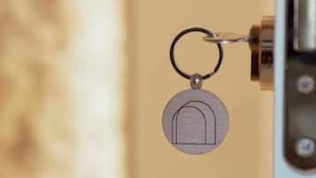 A keychain with a house-shaped keyring attached to a door handle.