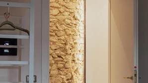 A room with a stone wall, a white door, and a white shelving unit. - Ferentino B&B (Ferentino)