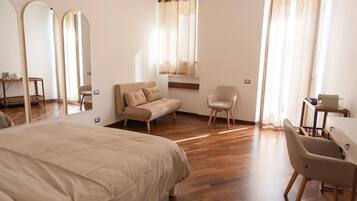 Une chambre à coucher comprenant un lit, un canapé, une chaise, un bureau et de grands miroirs.