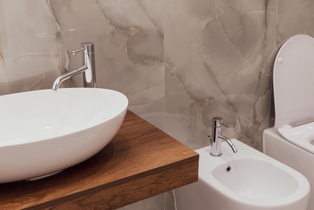 A bathroom with a large white sink, a smaller sink, and a toilet.