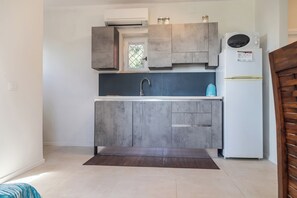 A compact kitchen with a built-in microwave, a sink, and a refrigerator. - Casa Orizzonte-Vista Sul Mare Del Circeo (Punta Rossa)