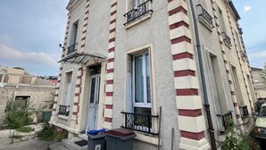 Ein mehrgeschossiges Gebäude im klassischen Stil, mit einer symmetrischen Fassade, großen Fenstern und einem zentralen Eingang.