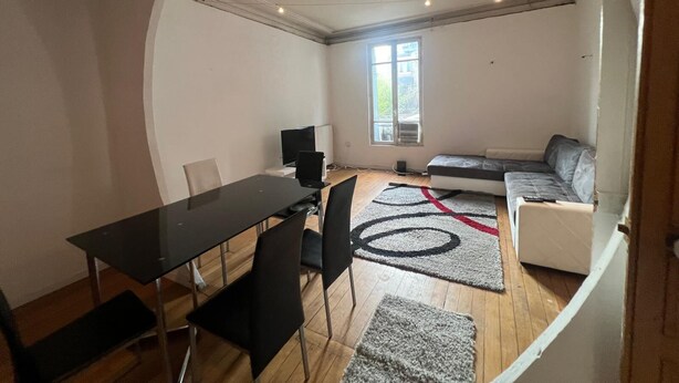 Ein kompakter Wohnbereich mit Essplatz, einer Couch, einem Fernseher und einem Fenster.