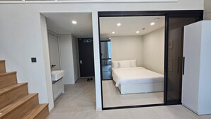 Et moderne hotelværelse med en seng, et badeværelse med håndvask og en trappe.