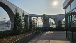 En udendørs terrasse med udsigt over byen, præget af moderne arkitektur og grønt.