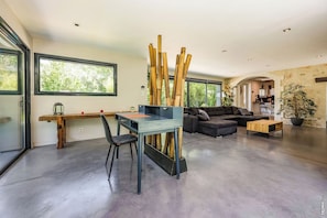 A modern living space with a desk, chair, sofa, and a large window. - House in Bouyssou - Nature and Elegant (Viterbe)