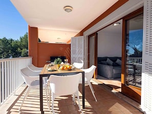 A balcony with a dining table, chairs, and a grill. - Chalet Mirador in Alcudia - Puerto de Alcudia (Alcúdia)