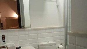 Un bagno con il water, un lavandino e uno specchio.