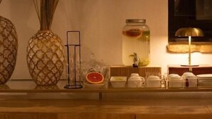 Un bancone in legno con vasi decorativi, uno specchio e una lampada.