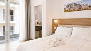 A hotel room with a bed, a bathroom with a mirror, and a balcony with a view. - Modern Seaside Apart in Marsalforn - 5E, Marsalforn Iz-Zebbug Gozo, Malta (Marsalforn Iz-Zebbug Gozo)