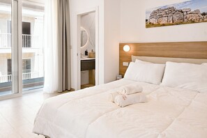 Ein Hotelzimmer mit Bett, Badezimmer mit Spiegel und Balkon mit Blick.