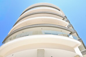 A multi-story building with a curved facade and large windows. - Modern Seaside Apart in Marsalforn - 5D, Marsalforn Iz-Zebbug Gozo, Malta (Marsalforn Iz-Zebbug Gozo)