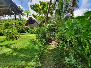 A lush garden with a gazebo, a small pond, and a variety of plants.