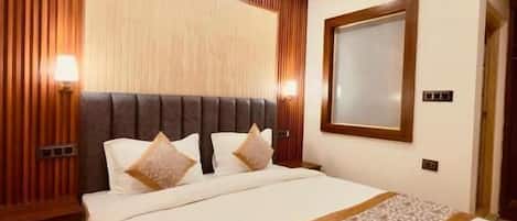Una habitación de hotel con techo de madera, una cama con cabecera, una mesita de noche y una mesilla.